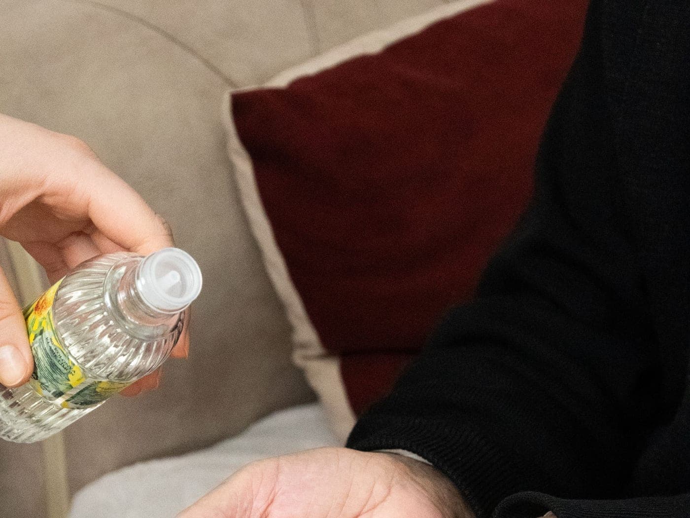 Verre d'eau tendu à une personne âgée assise dans son fauteuil