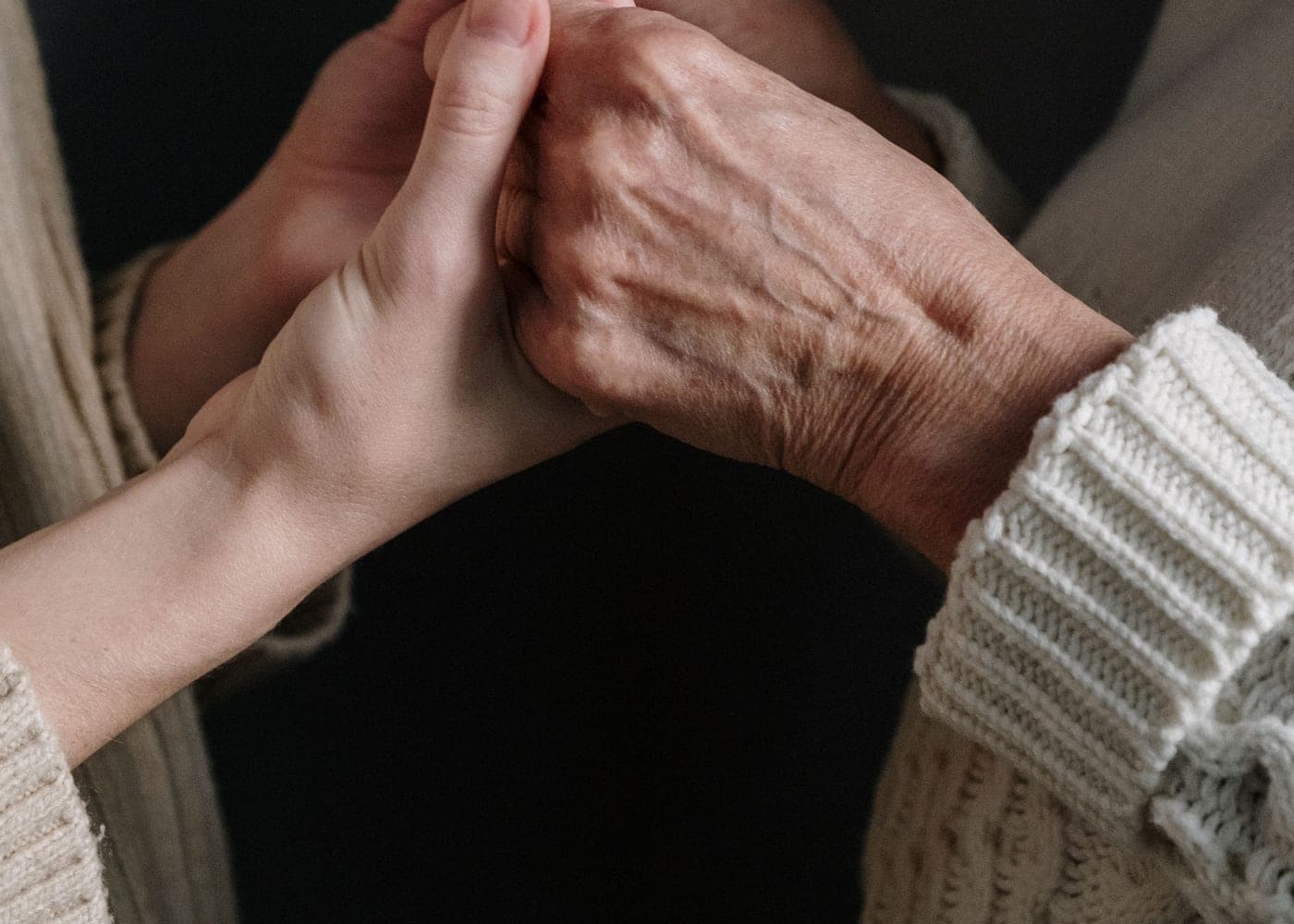 Deux mains l'une dans l'autre, celle d'une personne âgée tenue par une plus jeune