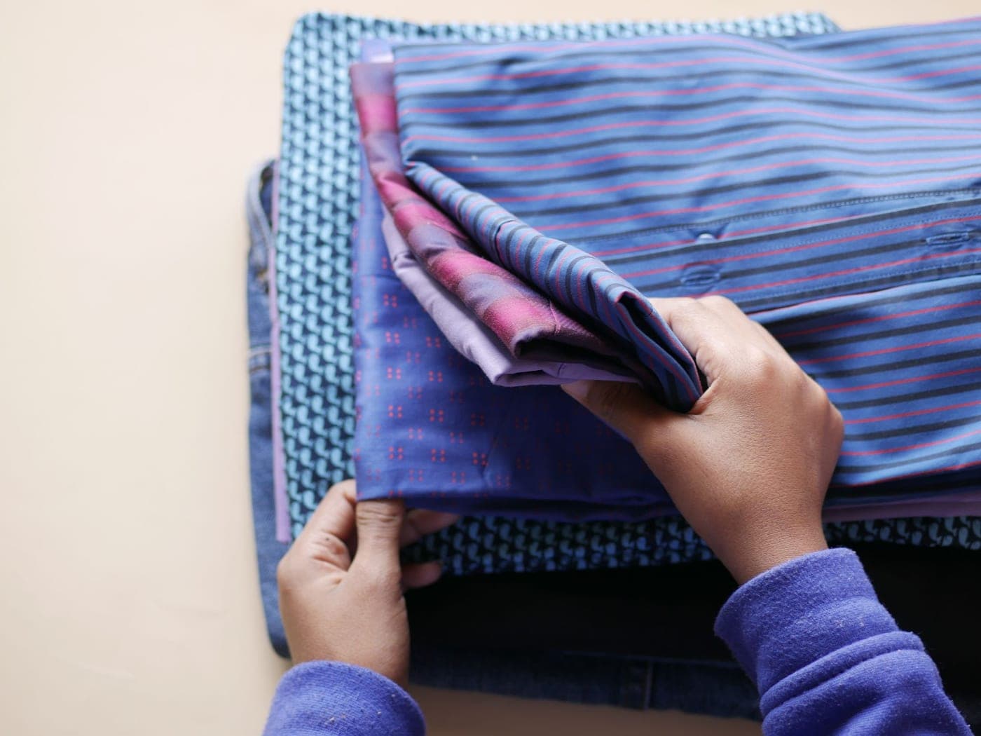 Mains pliant du linge posé en pile