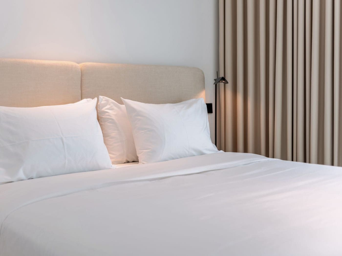 Lit refait au linge blanc, chambre prête pour le voyageur suivant